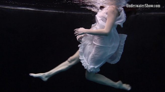 Модель в белом платье под водой позирует и светит писюлей и упругими сисями prew 3
